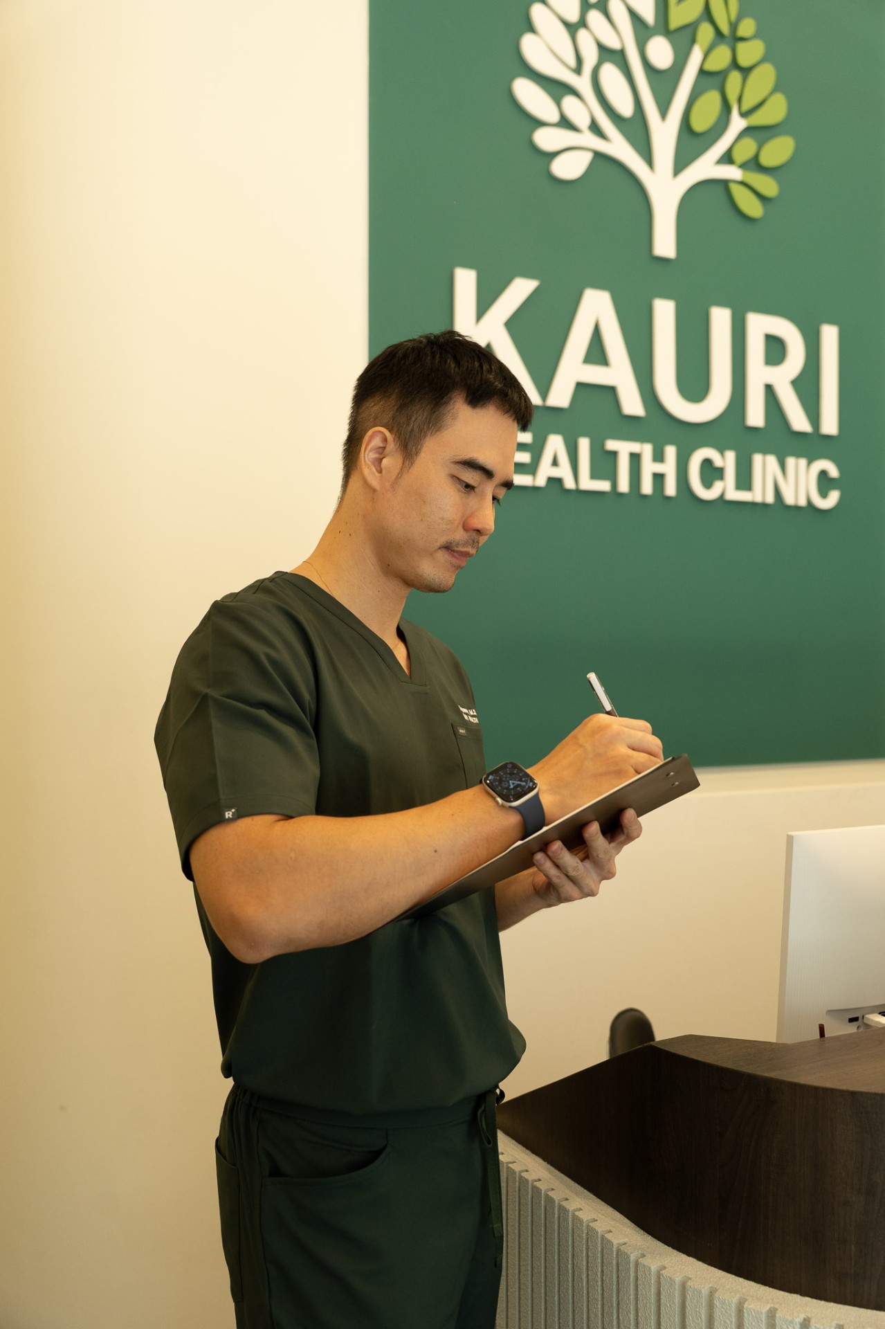 Kauri Health Clinic physician reviewing patient notes at reception